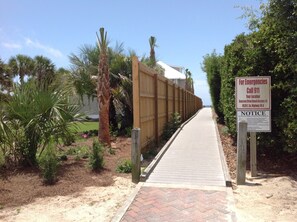 Access the beach via this paved pathway, marked by a sign at Seacrest Drive Beach Access #5.