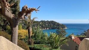 A staircase leading to a coastal area with a view of the sea and houses in the background. - Furnished 3 STARS Golf St Tropez RAYOL CANADEL Facing the SEA with POOL (Rayol-Canadel-sur-Mer)