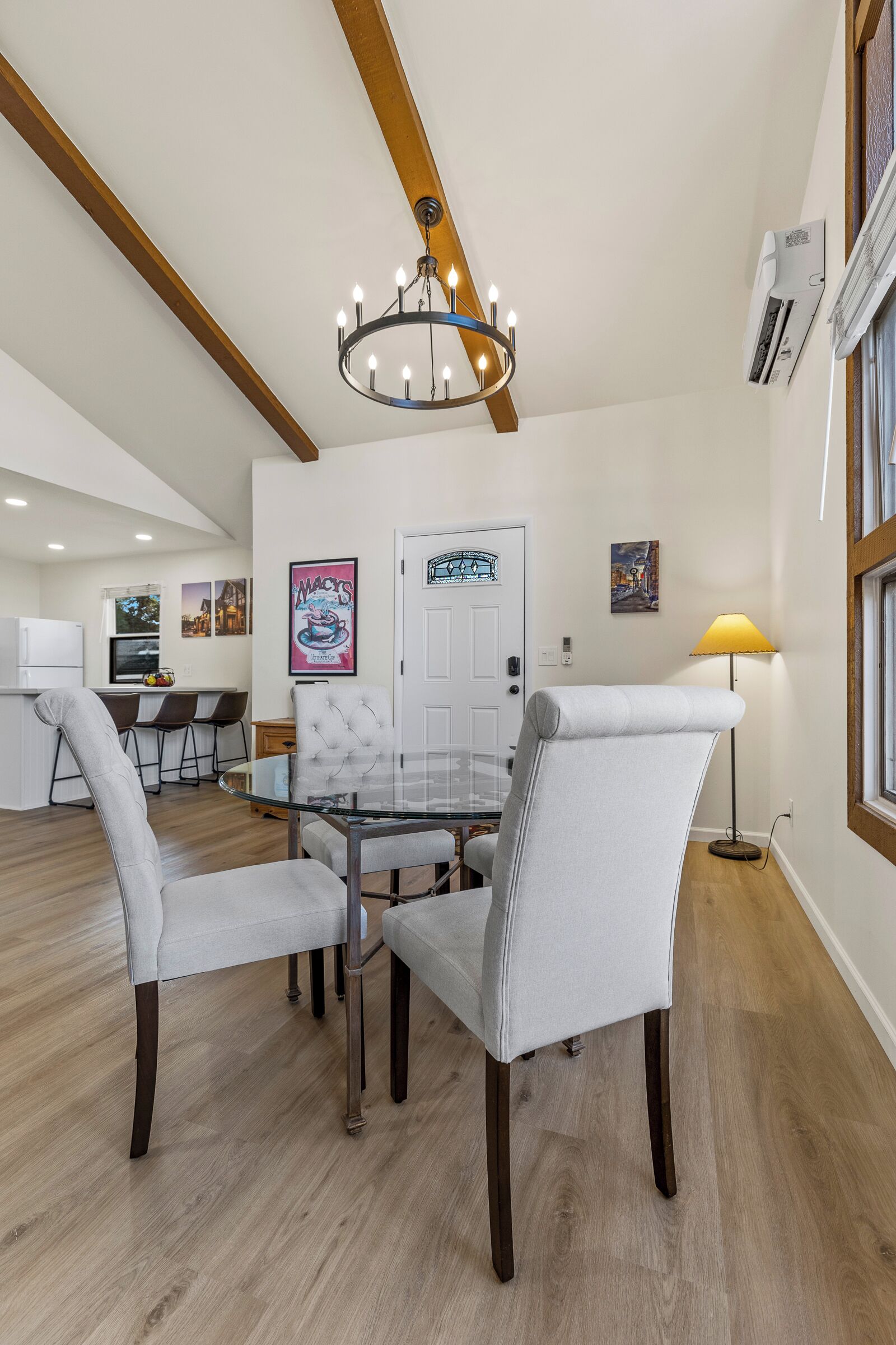 A modern kitchen with white cabinets, a built-in oven, and a stainless steel refrigerator.