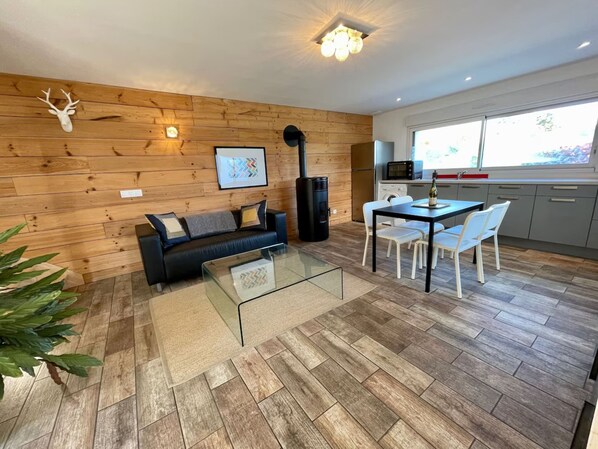 A modern living room with a glass coffee table, a sofa, and a fireplace.