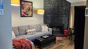 A cozy living room with a sofa, a coffee table, and a fireplace.