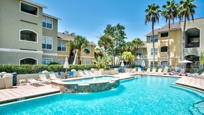 A swimming pool with lounge chairs and palm trees. - Charming, newly reno 1Bdrm condo, minutes from beautiful Clearwater Beach (Clearwater)