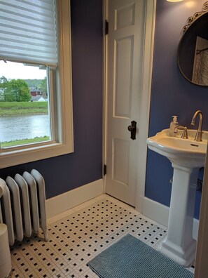 A bathroom with a white radiator, a sink with a soap dispenser, a door, and a window with blinds. - Stonehouse w/ Hot Tub, Walk to GAP Trail & Town (Confluence)