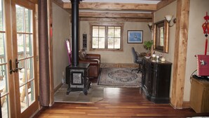 Un salon chaleureux avec une cheminée, un plancher en bois, un canapé en cuir et un tapis.