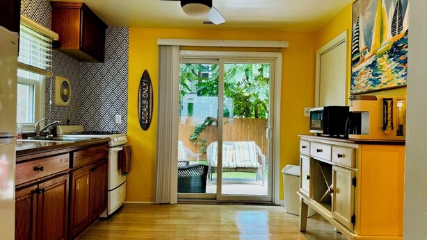 Una cucina con mobili in legno, un frigorifero bianco, un forno a microonde e una macchina da caffè.