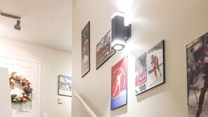 A staircase with a handrail, a door with a wreath, and several framed posters on the wall. - Ski In/out For Both Downhill And Cross-country (Vernon)