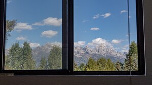 A window view of a mountain range with trees in the foreground. - Townhouse near GTNP and Yellowstone -Spectacular Views - 2-3 bed-2 bath (Jackson)