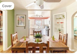 Un coin repas avec une table en bois, des chaises et un ventilateur de plafond.