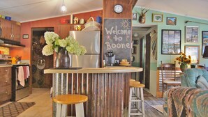 A kitchen with a wooden island, a refrigerator, and a chalkboard sign that says "Welcome to Boone".
