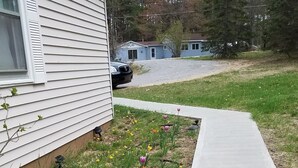 A residential area with a concrete sidewalk, a grassy lawn, and a house with white siding. - Beautiful Sunsets, Trails, Wildlife and All Out of Doors to enjoy (Atlanta)