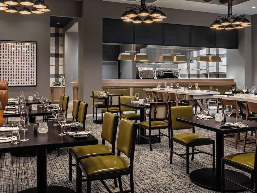 A restaurant with multiple dining tables, chairs, and a bar area.
