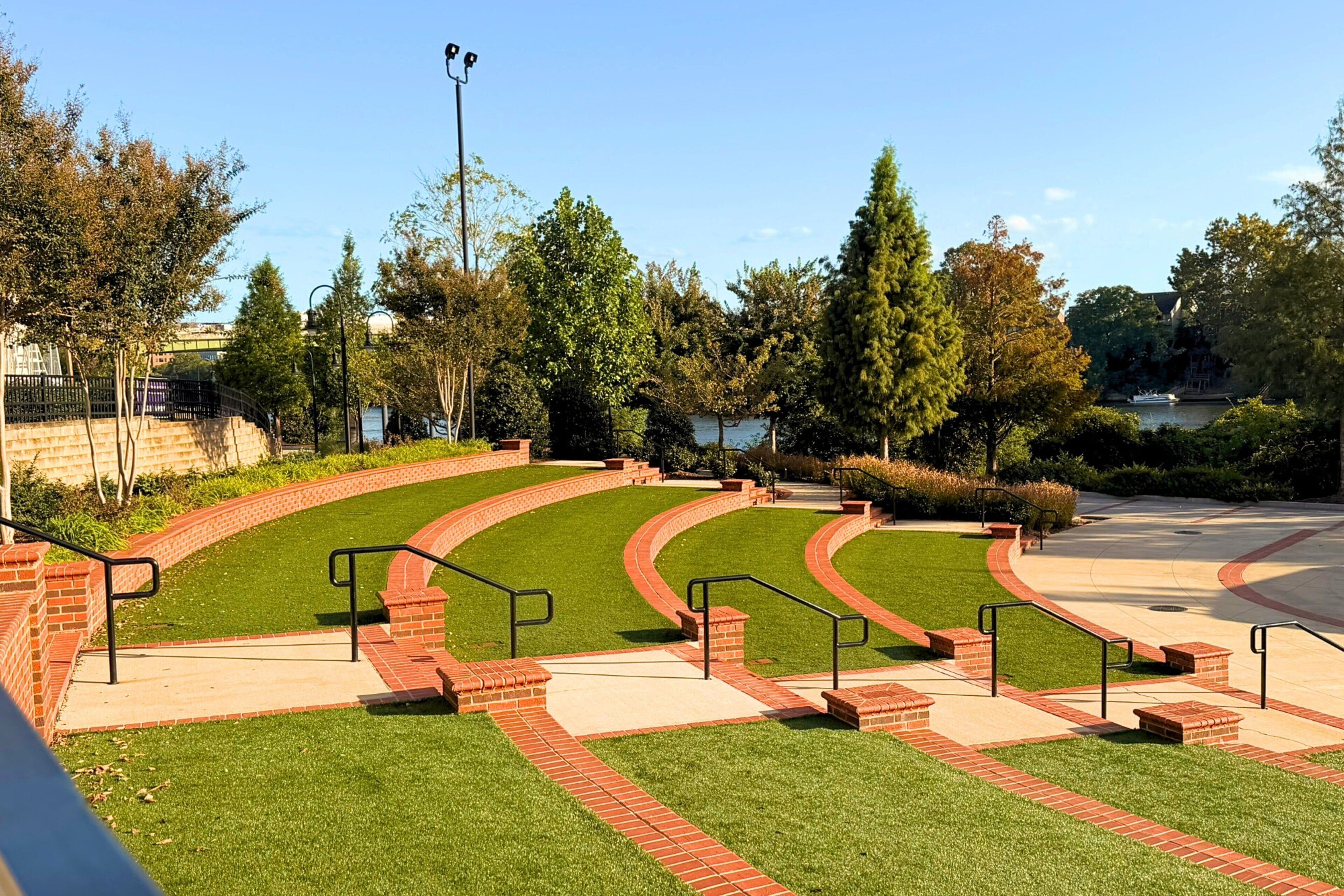 A landscaped outdoor area with tiered steps, brick pathways, and green lawns.