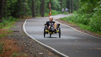 A person riding a motorcycle on a forested road.
