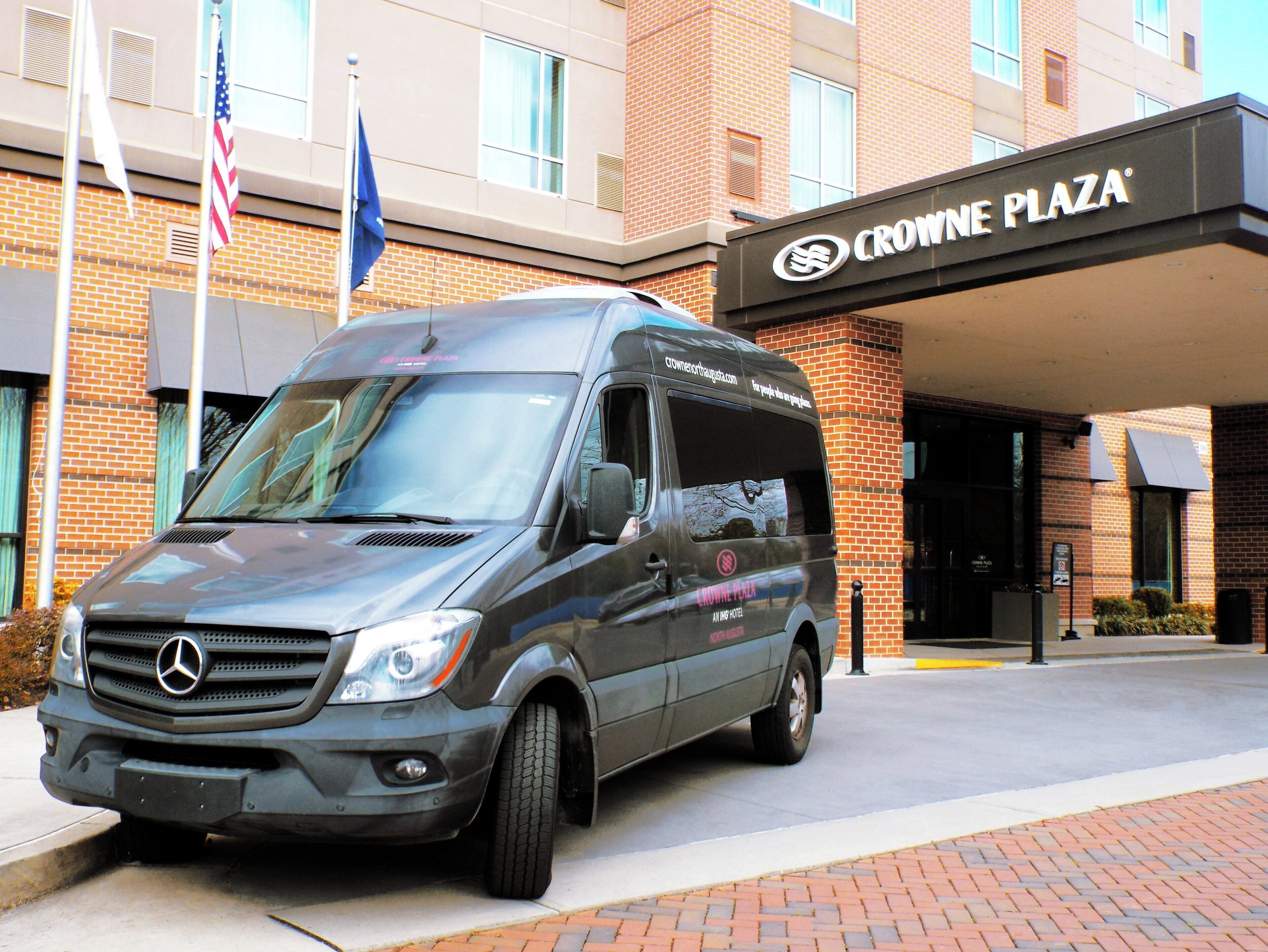 A Mercedes-Benz van parked in front of Crowne Plaza hotel.