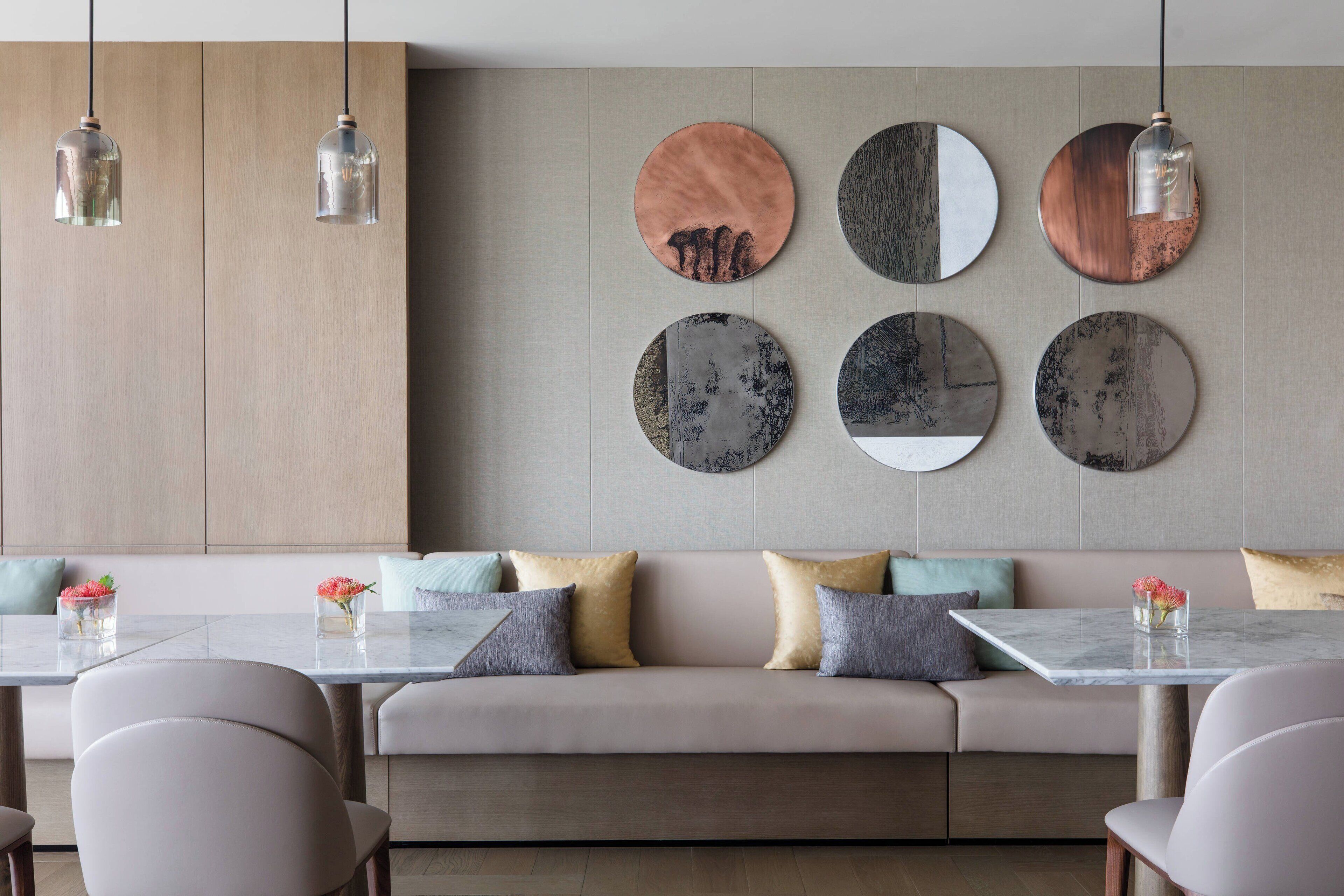 Ein modernes Interieur mit einer Couch, einem Esstisch und Pendelleuchten.