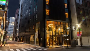 Un hôtel moderne doté d’une façade en verre remarquable, de plusieurs étages et de fenêtres illuminées.