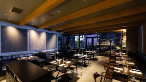 Un restaurant moderne doté d’une grande salle à manger, de banquettes et d’un bar.