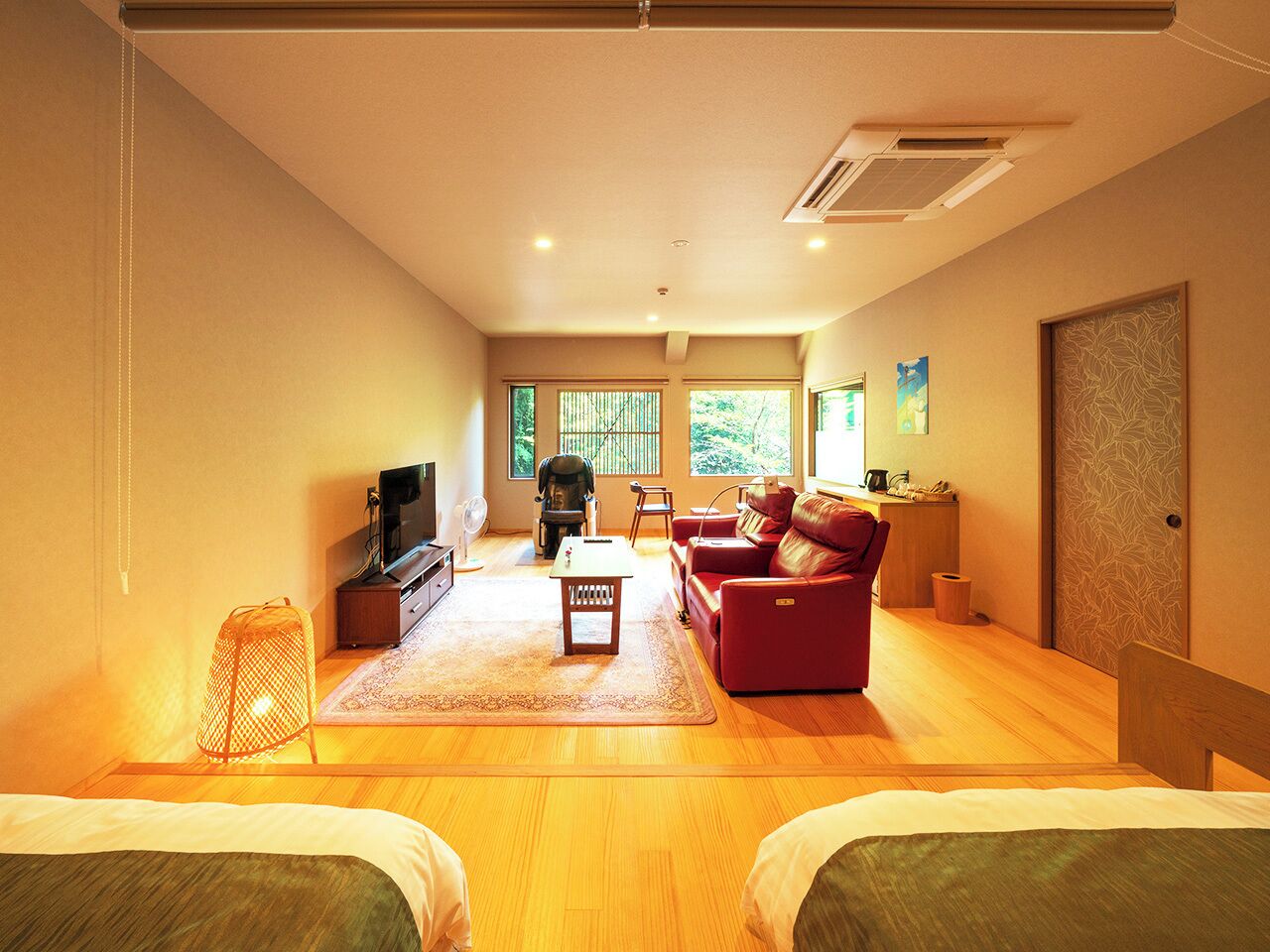 A spacious living room with a sofa, a TV, and a small table.