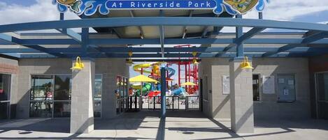 The entrance to Rexburg Rapids at Riverside Park with a covered area and a water park visible in the background.