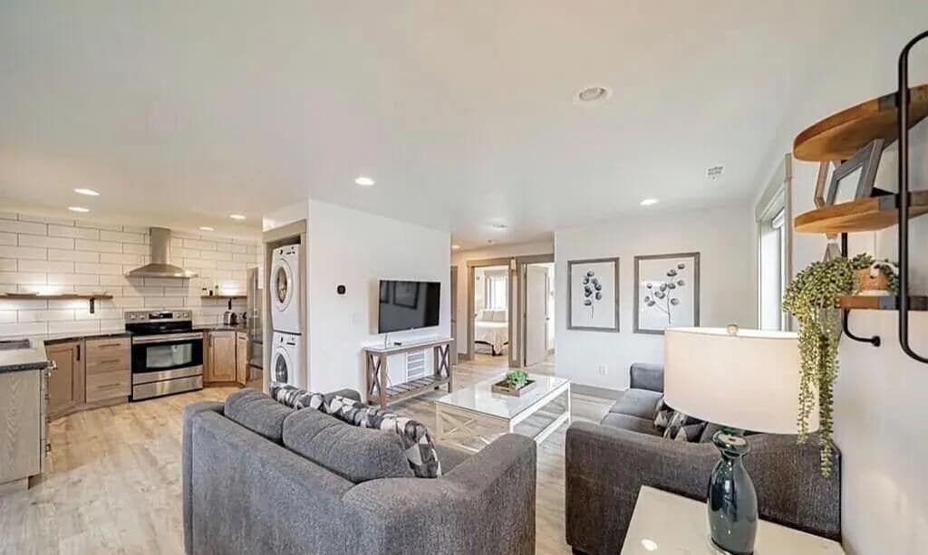 A modern living room with a grey sofa, a coffee table, and a TV.
