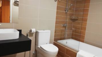 A bathroom with a toilet, sink, and shower.
