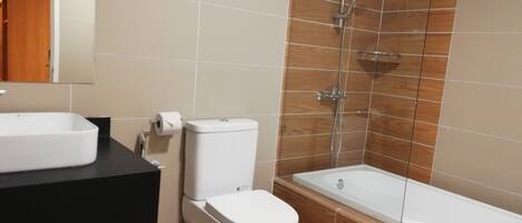 Un baño con inodoro, lavabo y ducha.