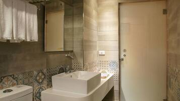 A modern bathroom with a toilet, a sink, and a mirror.