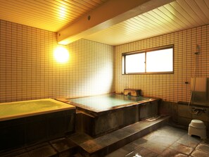 A traditional Japanese-style bathroom with a wooden bathtub, a window, and tiled walls. - Pension Raisin (Kusatsu)