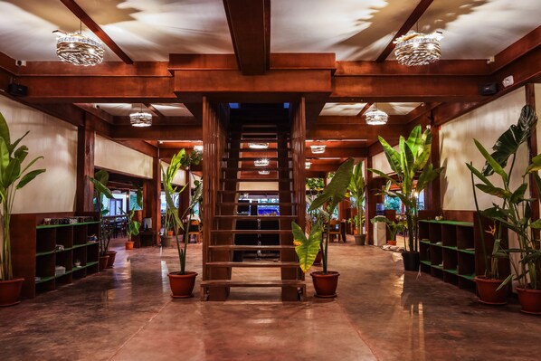 A wooden staircase in a hallway with potted plants on either side. - Retreat Siargao Resort (General Luna)