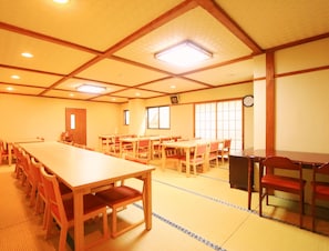 A conference room with a long table and chairs, a clock on the wall, and a large window. - Kawatatsu (Nozawaonsen)