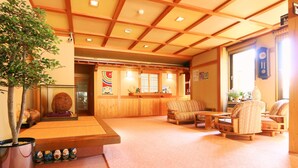 A traditional Japanese inn interior with tatami flooring, wooden furniture, and a reception area. - Kawatatsu (Nozawaonsen)