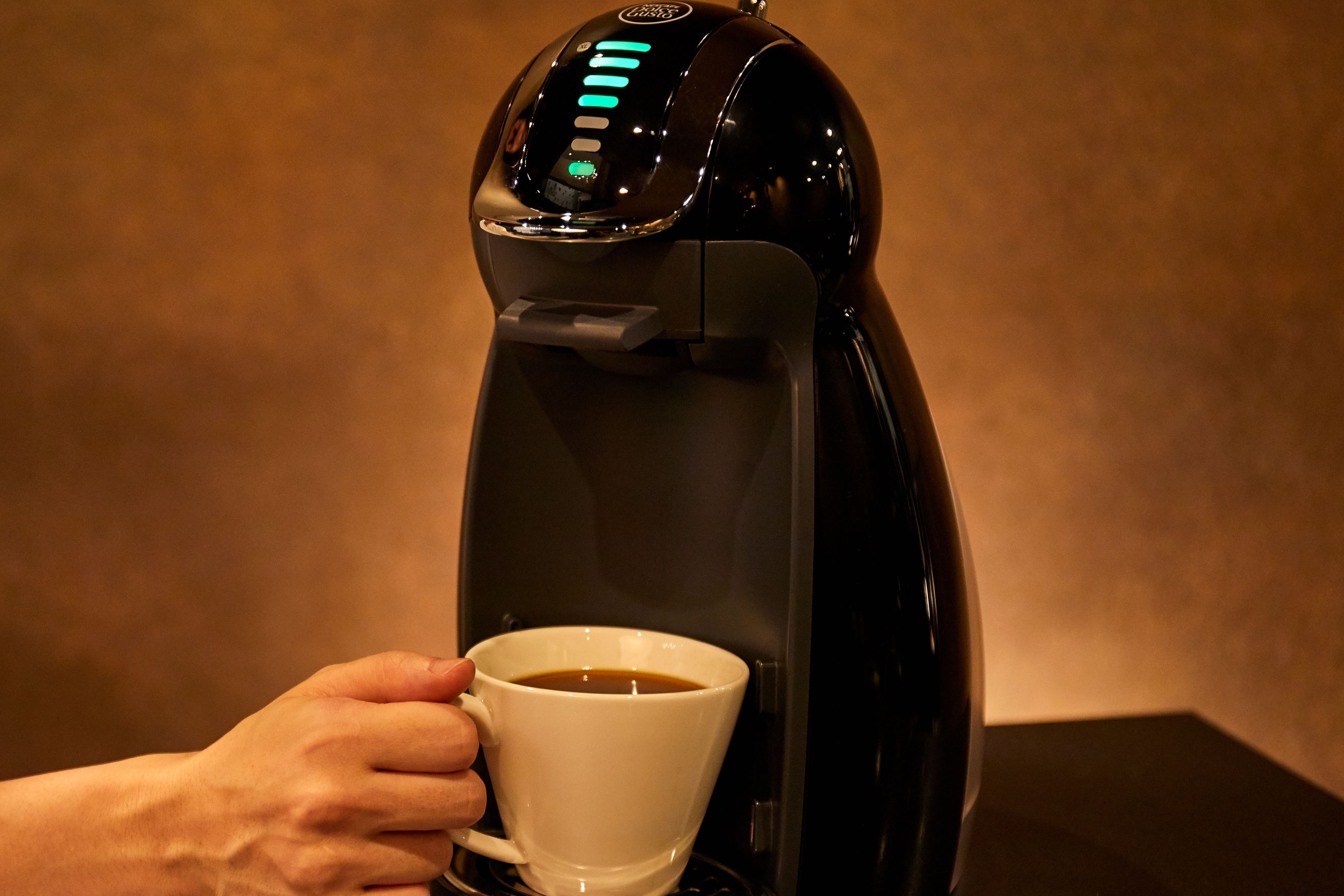 En kaffemaskin som häller kaffe i en kopp.