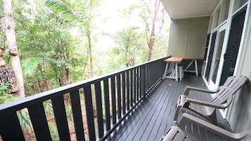 Enjoy outdoor dining or relaxation on this deck overlooking a lush forest.
