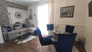 Un salon comprenant un canapé, une table basse et un coin repas avec des chaises et une table.