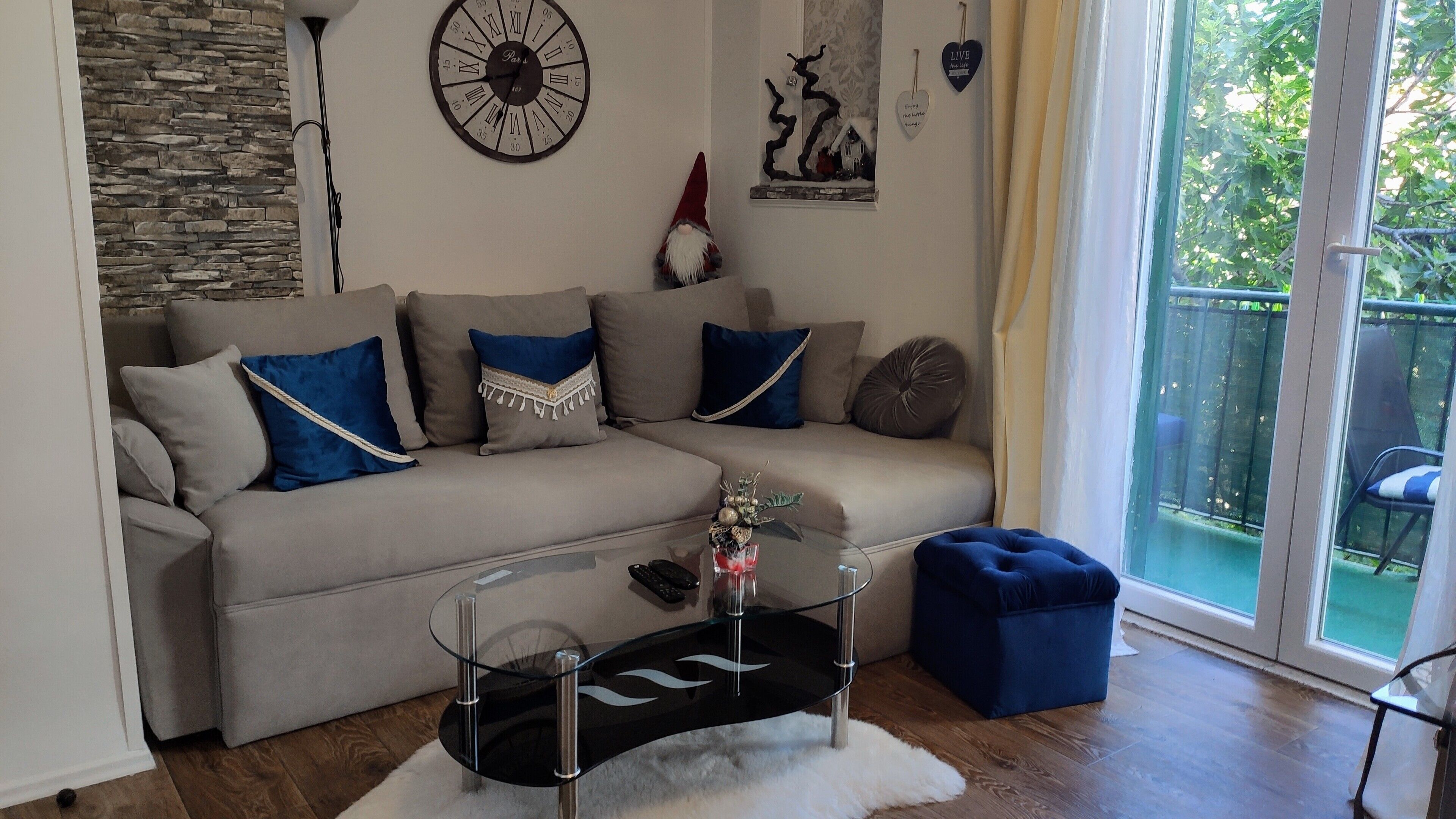 Un salon moderne avec un canapé d’angle beige, une table basse en verre et des coussins décoratifs.
