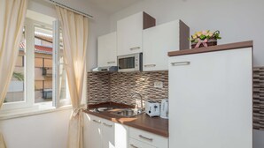 A modern kitchen with white cabinets, a microwave, a sink, and a toaster. - Elitte Apartment in canter,self check in /checkout (Split)