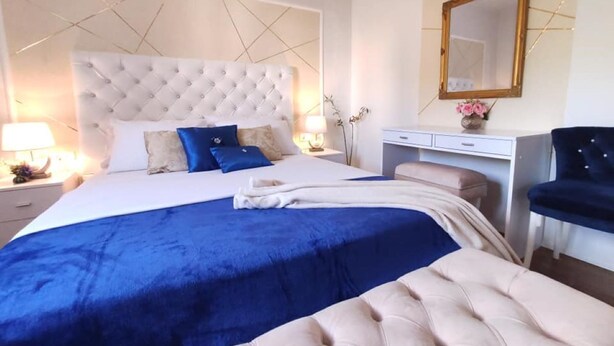 A hotel room with a large bed, a desk, a chair, and a mirror. - Elitte Apartment in canter,self check in /checkout (Split)