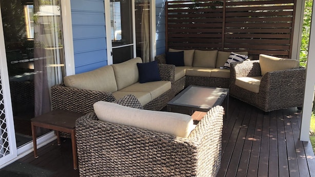 A covered patio with wicker furniture, including a sofa and armchairs, and a small table. - Kookaburra Cottage 71 Straight Hat Head (Hat Head)