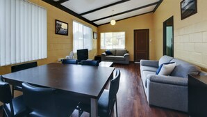Ein Zimmer mit einem großen Tisch und Stühlen, einer Couch und einem Fernseher.