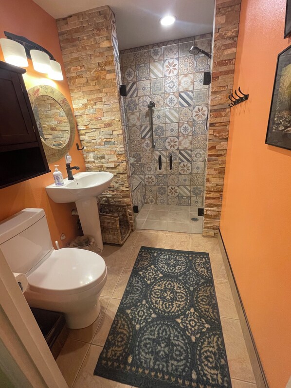 A bathroom with a toilet, sink, and shower.