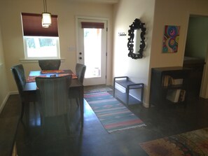 A dining area with a table, chairs, a rug, a door, and a wall-mounted mirror. - River/Mountain Getaway-Private, Large,In-Law Suite (Jamestown)