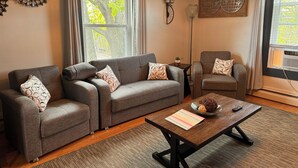 A modern living room with a grey sofa set, a coffee table, and a small side table. - Charming apt -2 Bedroom -Close to Beach/Sleeps 6 (Ipswich)