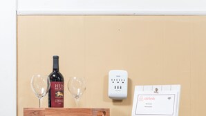 A wooden table with a wine bottle, two glasses, and a framed Airbnb sign. - Charming apt -2 Bedroom -Close to Beach/Sleeps 6 (Ipswich)
