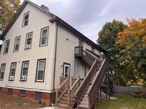 Un bâtiment à deux étages avec un escalier en bois menant à un balcon.
