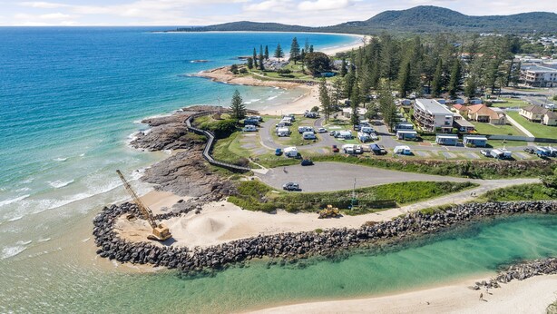 An aerial view of a coastal resort with a beach, parking area, and buildings. - All Linen Included * Center of Town * BBQ *Air Con * Private Covered Patio* (South West Rocks)