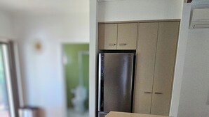 A modern kitchen with a built-in refrigerator, wooden flooring, and a neutral color palette. - Comfortable air conditioned, pet friendly holiday home with large open... (South West Rocks)
