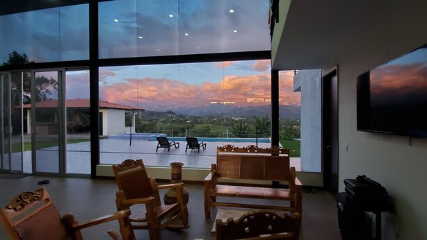 A room with large windows overlooking a pool and a scenic view of mountains. - Unforgettable vacations, beautiful farm with astonishing and mountains view (Circasia)
