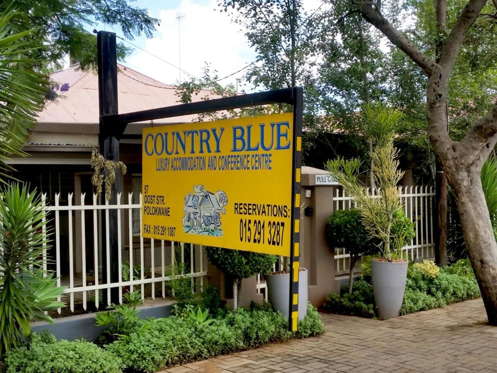 A sign for Country Blue, a luxury accommodation and conference center, with contact details and a location address.