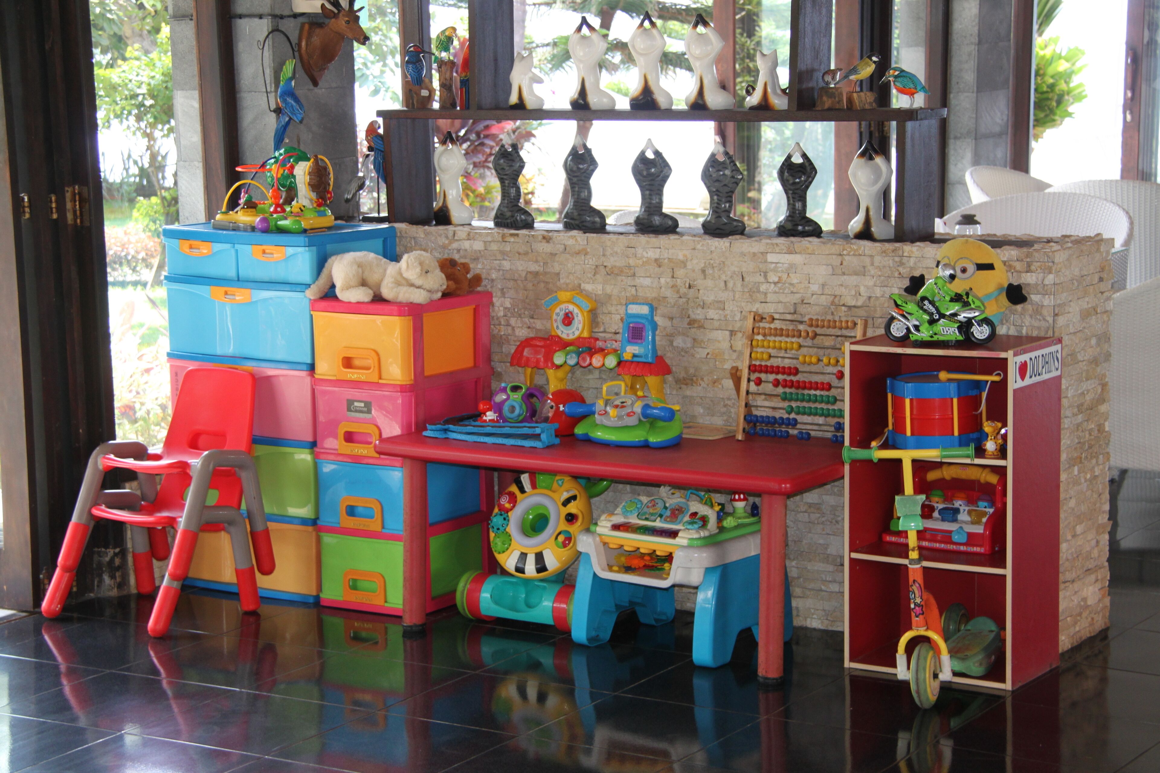 A children's play area with colorful storage units, a small table, and toys.