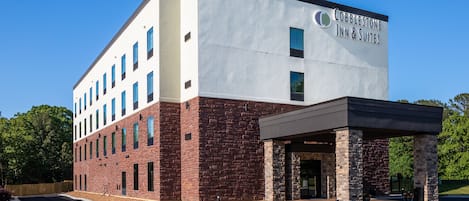 Un bâtiment moderne de la chaîne Cobblestone Inn & Suites, avec une façade en briques et une entrée abritée.